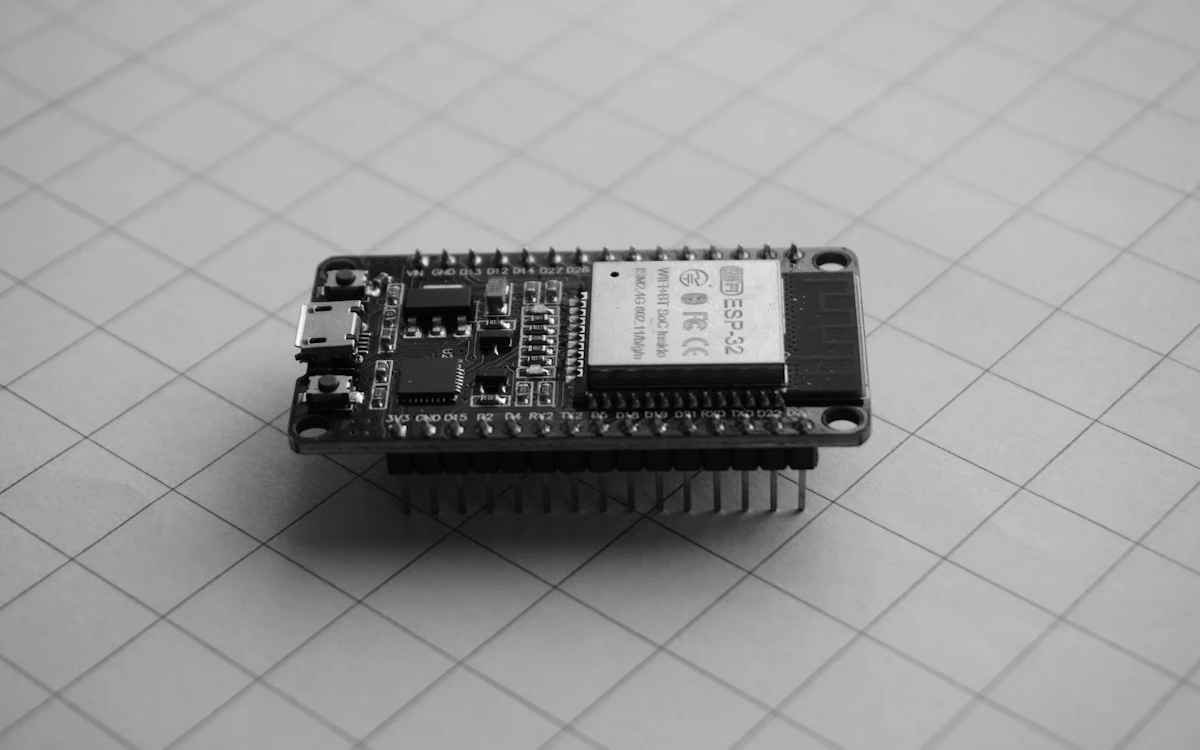 Placa de desenvolvimento ESP32 sobre a base quadriculada de uma bancada
